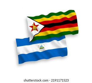 National vector fabric wave flags of Nicaragua and Zimbabwe isolated on white background. 1 to 2 proportion.