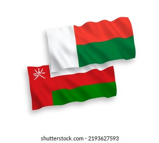 National vector fabric wave flags of Sultanate of Oman and Madagascar isolated on white background. 1 to 2 proportion.