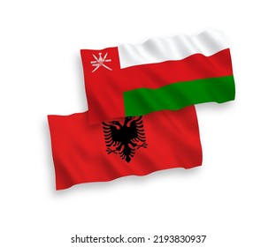 National vector fabric wave flags of Sultanate of Oman and Albania isolated on white background. 1 to 2 proportion.