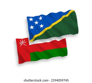 National vector fabric wave flags of Sultanate of Oman and Solomon Islands isolated on white background. 1 to 2 proportion.