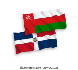 National vector fabric wave flags of Sultanate of Oman and Dominican Republic isolated on white background. 1 to 2 proportion.