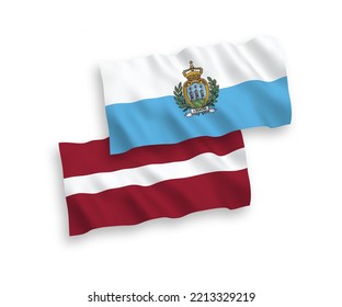 National vector fabric wave flags of Latvia and San Marino isolated on white background. 1 to 2 proportion.