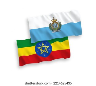 National vector fabric wave flags of San Marino and Ethiopia isolated on white background. 1 to 2 proportion.