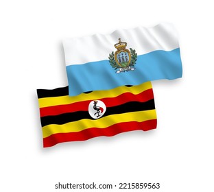 National vector fabric wave flags of San Marino and Uganda isolated on white background. 1 to 2 proportion.