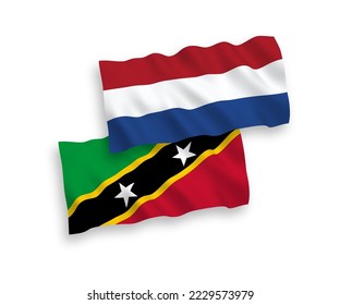 National vector fabric wave flags of Federation of Saint Christopher and Nevis and Netherlands isolated on white background. 1 to 2 proportion.