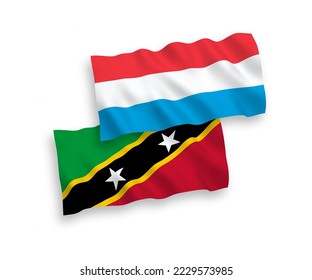 National vector fabric wave flags of Federation of Saint Christopher and Nevis and Luxembourg isolated on white background. 1 to 2 proportion.
