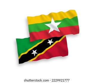 National vector fabric wave flags of Federation of Saint Christopher and Nevis and Myanmar isolated on white background. 1 to 2 proportion.