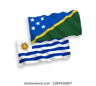 National vector fabric wave flags of Oriental Republic of Uruguay and Solomon Islands isolated on white background. 1 to 2 proportion.