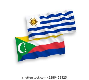 National vector fabric wave flags of Oriental Republic of Uruguay and Union of the Comoros isolated on white background. 1 to 2 proportion.