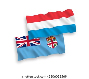 National vector fabric wave flags of Republic of Fiji and Luxembourg isolated on white background. 1 to 2 proportion.