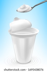 Natural yogurt in plastic packages and spoon with yogurt