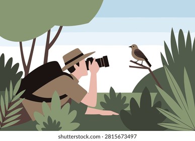 Nature photographer lying down in green foliage to capture a professional photo of a small wild bird on a branch.