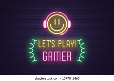 Neon composition of headline Lets Play Gamer. Glowing Neon Emoji with Headphones and text Lets Play Gamer. Bright digital signboard for Gaming industry, Vector. Yellow, pink and green color