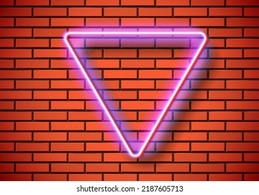 Neon frame with triangle shape on the red brick wall. Classic rectangular 80s styled shiny glowing neon sign