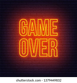 Neon game over sign on brick wall background.