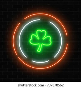 Neon glowing clover leaf sign on a dark brick wall background. Green shamrock as Irish national holiday symbol in circle frames. Vector illustration.