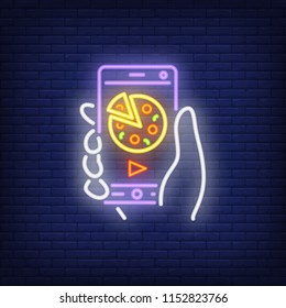 Neon icon of online pizza order. Hand holding mobile phone with pizza and play sign on screen. Food delivery concept. Can be used for neon signs, posters, billboards, banners