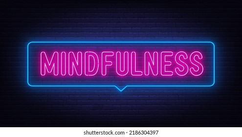 Neon lettering mindfulness on brick wall background.