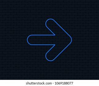 Neon light. Arrow sign icon. Next button. Navigation symbol. Glowing graphic design. Brick wall. Vector