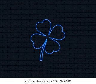 Neon light. Clover with four leaves sign icon. Saint Patrick symbol. Glowing graphic design. Brick wall. Vector