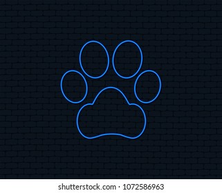 Neon light. Dog paw sign icon. Pets symbol. Glowing graphic design. Brick wall. Vector