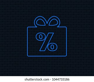 Neon light. Gift box sign discount icon. Present symbol. Glowing graphic design. Brick wall. Vector