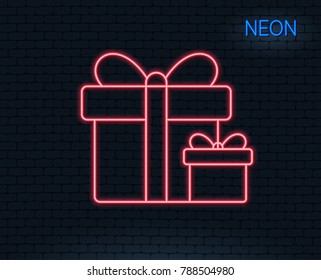 Neon light. Gift boxes line icon. Present or Sale sign. Birthday Shopping symbol. Package in Gift Wrap. Glowing graphic design. Brick wall. Vector