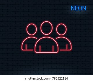 Neon light. Group line icon. Users or Teamwork sign. Person silhouette symbol. Glowing graphic design. Brick wall. Vector