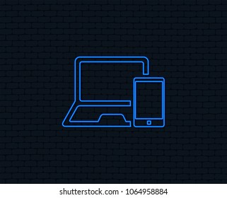 Neon light. Mobile devices sign icon. Notebook with smartphone symbol. Glowing graphic design. Brick wall. Vector