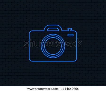 Neon light. Photo camera sign icon. Digital photo camera symbol. Glowing graphic design. Brick wall. Vector