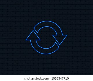 Neon light. Rotation icon. Repeat symbol. Refresh sign. Glowing graphic design. Brick wall. Vector
