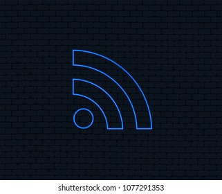 Neon light. RSS sign icon. RSS feed symbol. Glowing graphic design. Brick wall. Vector