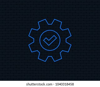 Neon light. Service icon. Cogwheel with tick sign. Check symbol. Glowing graphic design. Brick wall. Vector