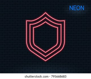 Neon light. Shield line icon. Protection or Security sign. Defence or Guard symbol. Glowing graphic design. Brick wall. Vector