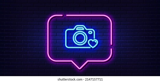 Burbuja de habla de luz neón. Icono de la línea de la cámara fotográfica. Señal de fotografía de amor. Símbolo del corazón. Fondo neón de luz. Línea de brillo de la cámara fotográfica. Banner de pared de ladrillo. Vector