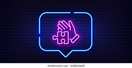 Neon light speech bubble. Puzzle line icon. Hand with Jigsaw piece sign. Business challenge symbol. Neon light background. Puzzle glow line. Brick wall banner. Vector