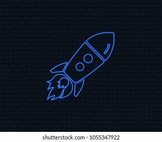Neon light. Start up icon. Startup business rocket sign. Glowing graphic design. Brick wall. Vector