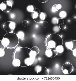 Neon monochromatic bokeh effect seamless pattern. Dark background with Glowing sparkling circles and rings in black and white colors. 