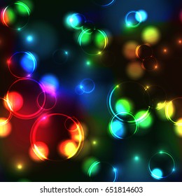 Neon rainbow bokeh effect seamless pattern. Dark background with Glowing sparkling circles and rings in spectrum colors. 