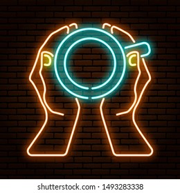 Neon sign. Hands holding a cup top view. Against the background of a brick wall. Tea, coffee, cocoa, hot chocolate.