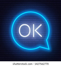 Neon sign ok in speech bubble frame on dark background. Light banner on the wall background.