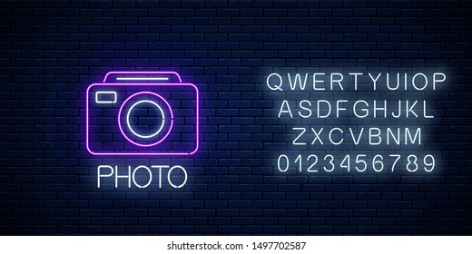 Neon sign of photo camera symbol with text and alphabet on dark brick wall background. Photography camera sign. Photo logo. Vector illustration.