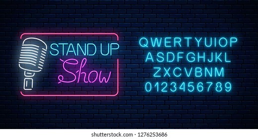 Neon stand up show sign with retro microphone on a brick wall background. Comedy battle glowing signboard with alphabet. Vector illustration.