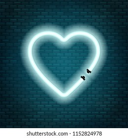 Neon tubes in the shape of a heart isolated on a brick wall background. Sign of love.