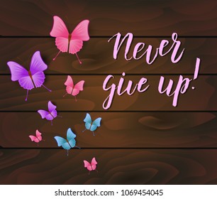 Never give up inspirational message on dark wooden background with butterflies.