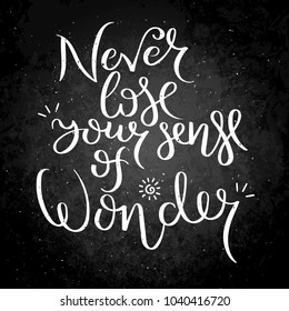 Never lose your sense of wonder. Hand written calligraphy quote motivation for life and happiness on blackboard. For postcard, poster, prints, cards graphic design.