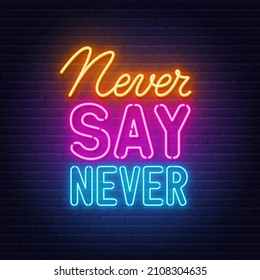 Never Say Never neon quote on a brick wall.