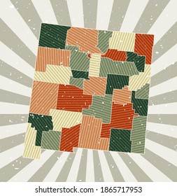 New Mexico vintage map. Grunge poster with a map of the US state in a retro color palette. Shape of New Mexico with a sunburst rays background. Vector illustration.