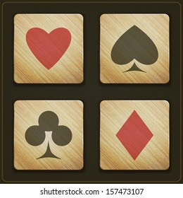 new set of wooden buttons with cards suits symbols on dark background