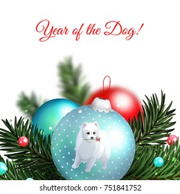 New Year tree ball with white Japanese Spitz, branches of a Christmas tree and beads in the foreground